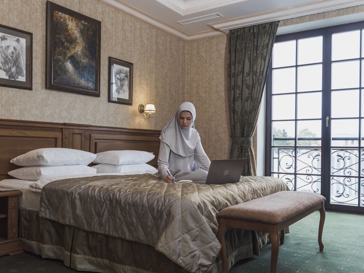 A person working on their books from a hotel room